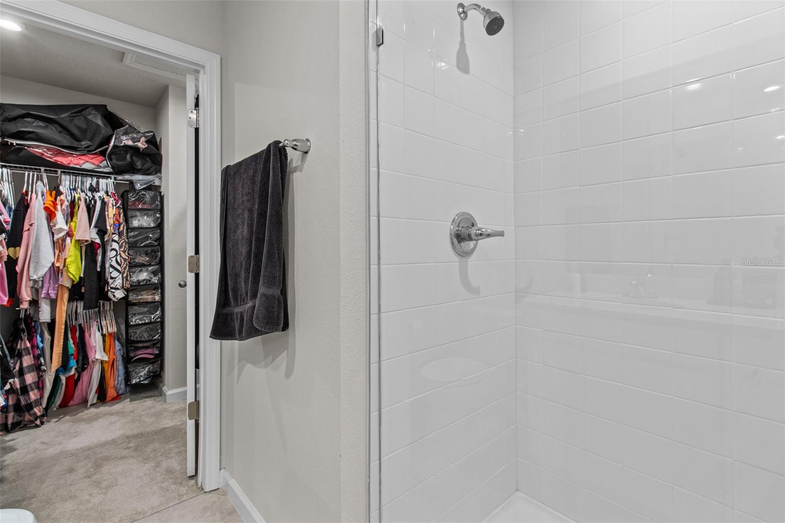 This spacious walk-in closet offers additional space to the right of the closet door.