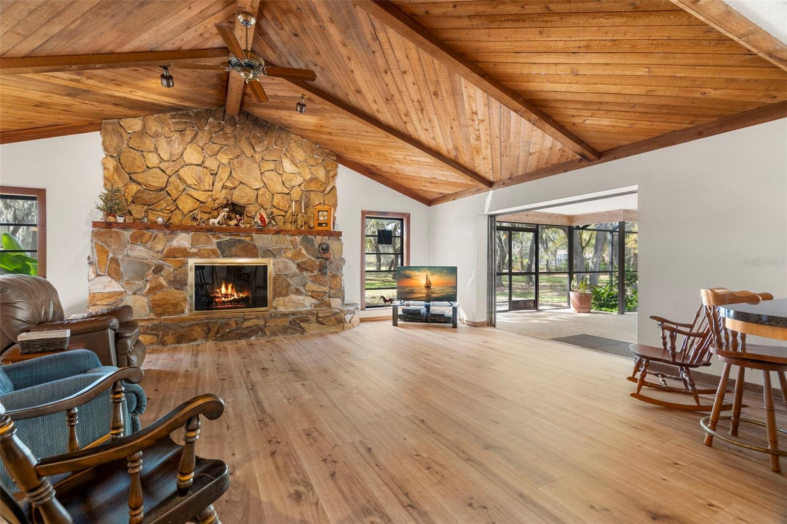 Great Room with vaulted ceilings, wood burning fireplace and wide plank luxury vinyl