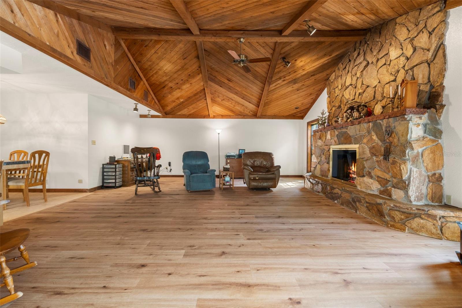 Great Room with vaulted ceilings, wood burning fireplace and wide plank luxury vinyl