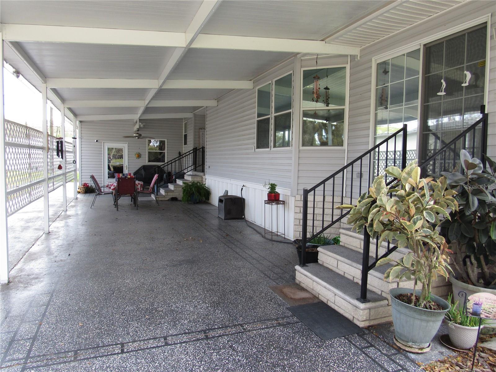 Decorative finished driveway, Florida room entry, carport & seating area.