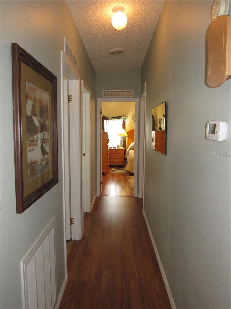 Hallway to main bathroom, laundry room, guest bedroom & primary bedroom.