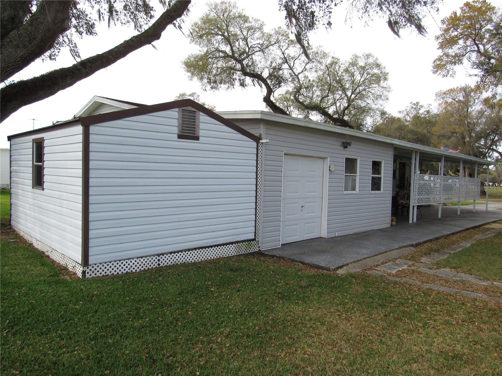 Attached freestanding shed with additional golf cart parking & ramp.