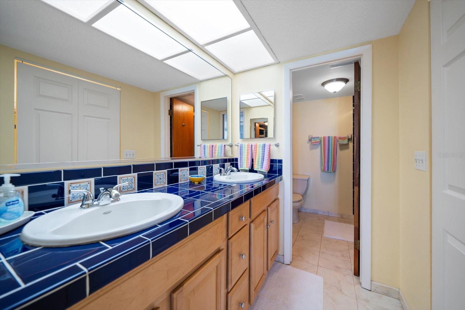 Master Bath has dual vanities in bathroom across from generous walkin closet.