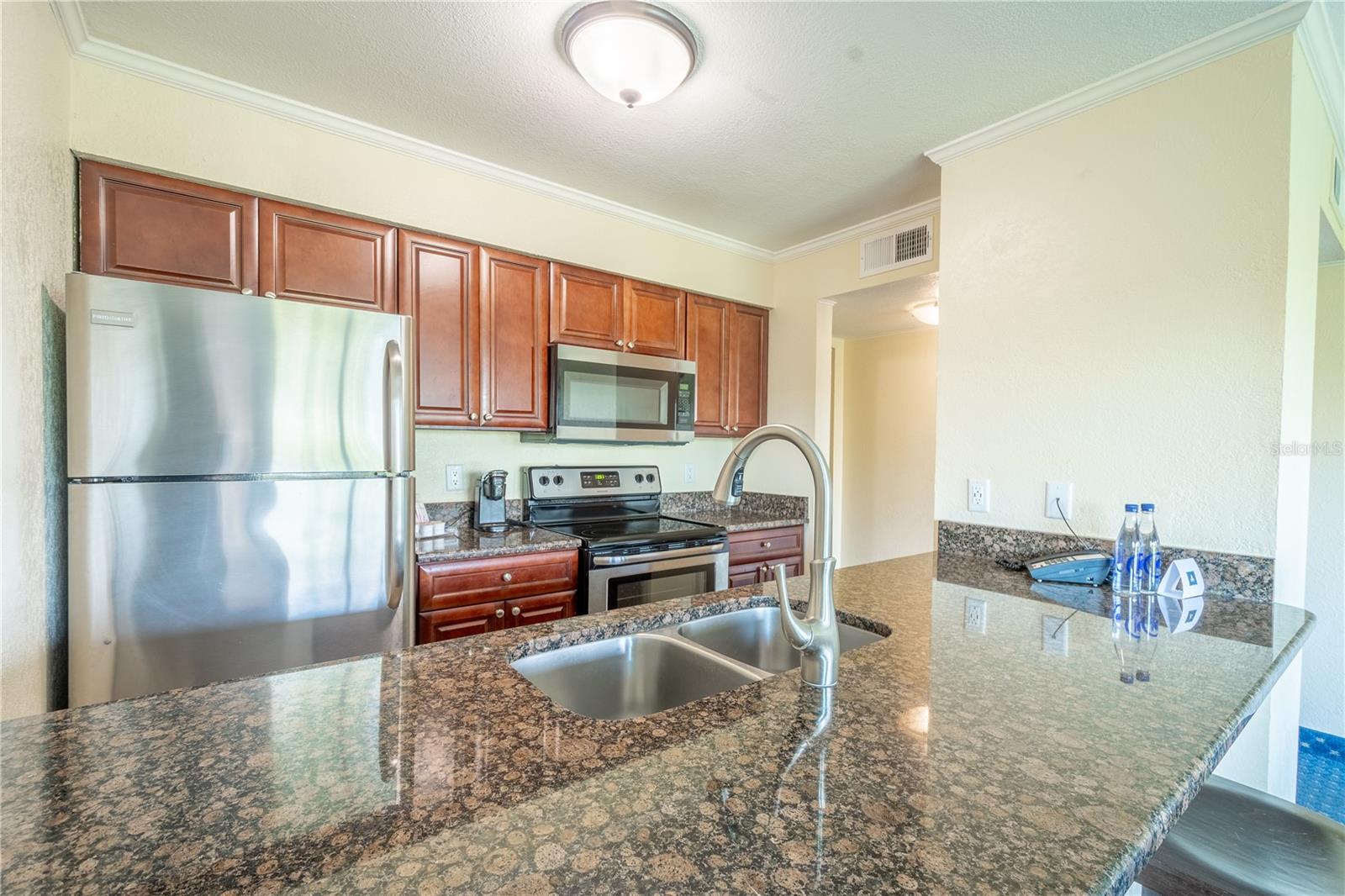 The kitchen features granite counters, and a suite of stainless steel appliances