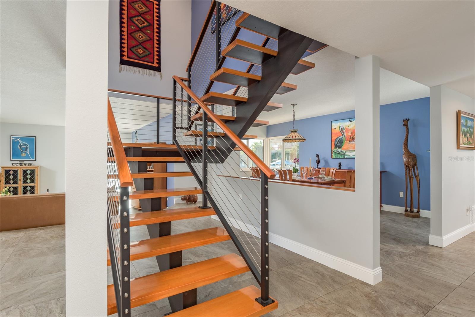 Dramatic Floating Staircase with metal rails and hardwood stairs