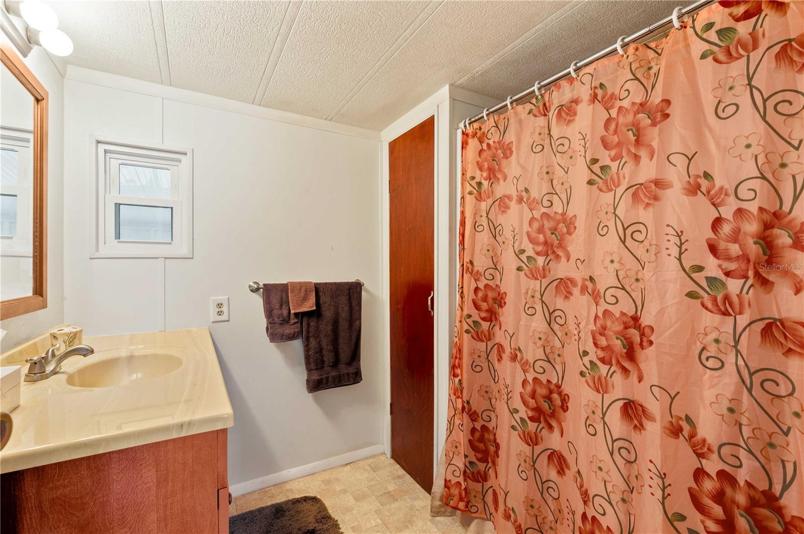 Main bathroom has step-in shower, updated vanity, and flooring.