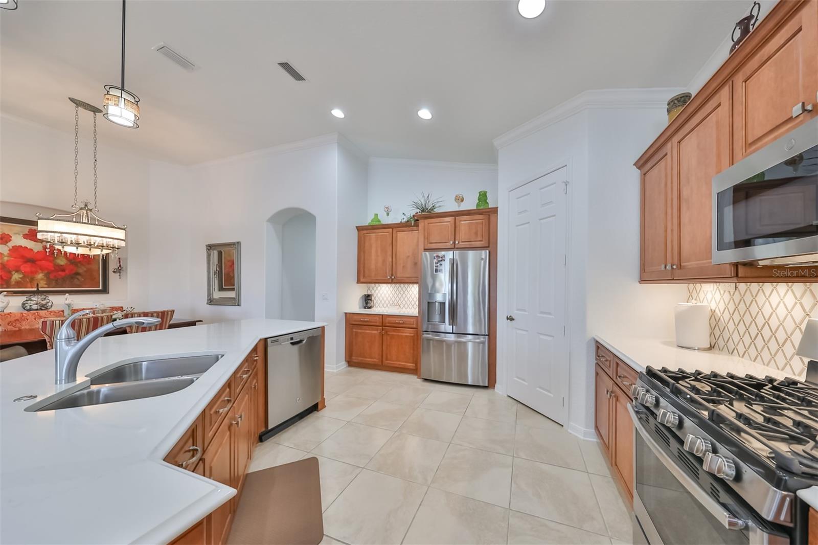 This kitchen boasts of newer, high-end stainless steel appliances, natural gas range and a large walk in pantry.