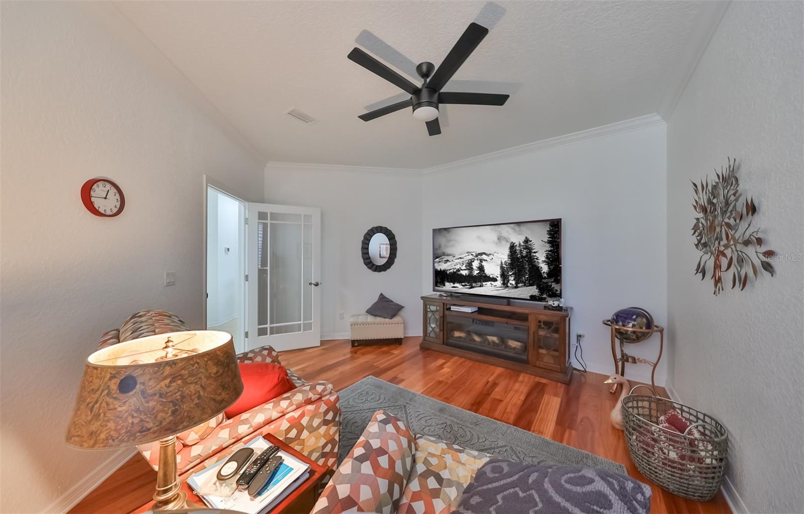 Den can be transformed into a movie, game, or card room! Entertain yourself or others in this large open area.  The glass door, wood floors and custom ceiling fan only add interest and elegance to the room.