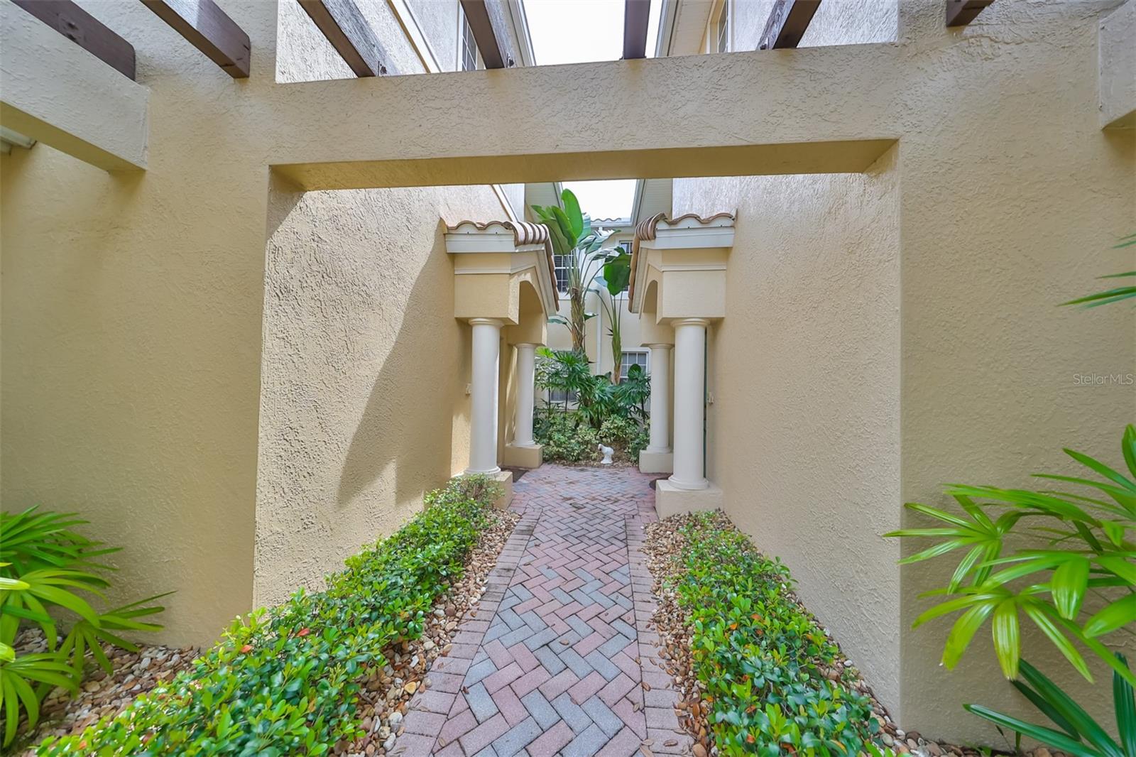 A lovely pergola invites you into the breezeway that leads you to the front door of this upstairs unit.