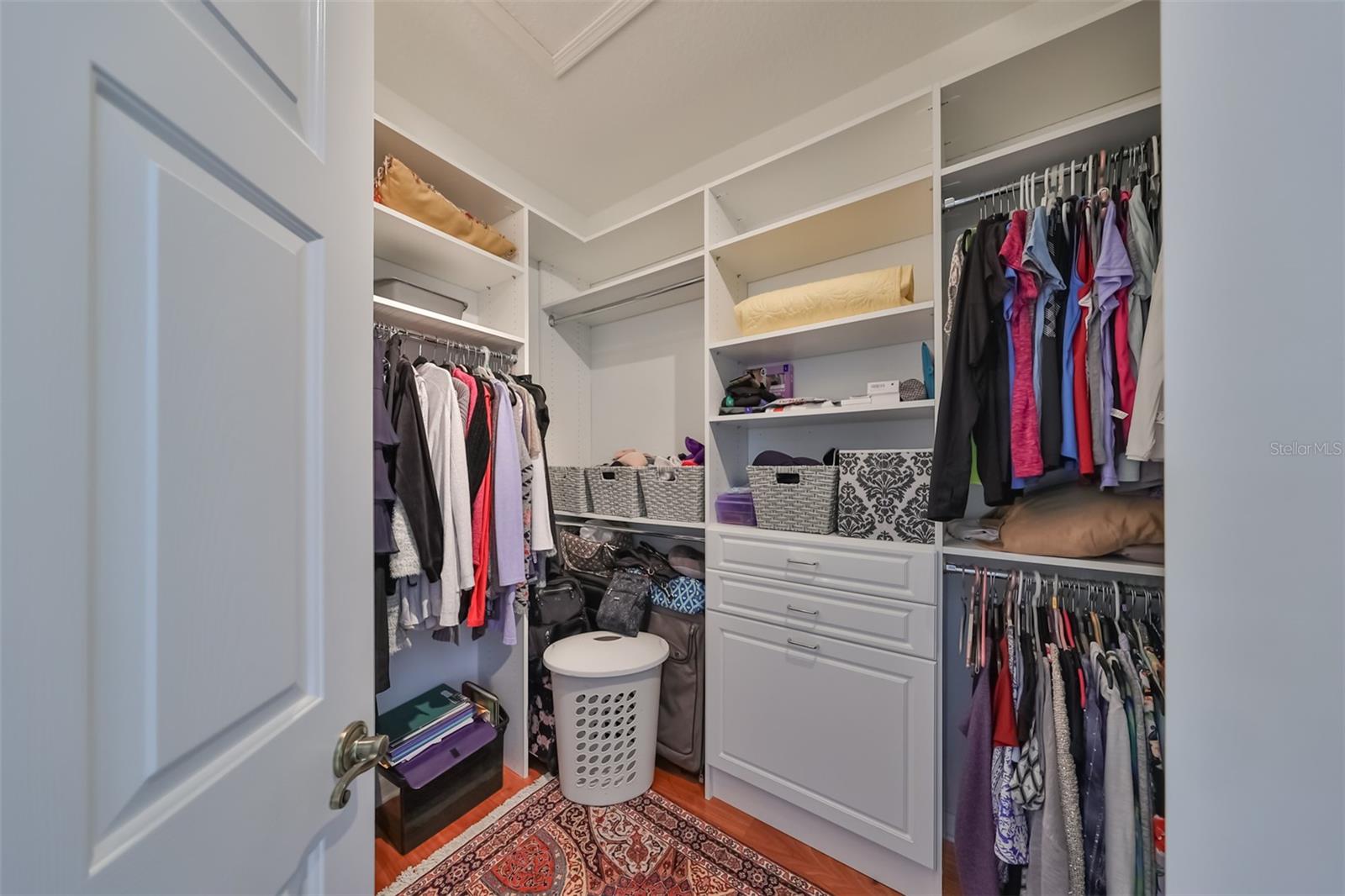 Large walk-in closet with California style shelving.