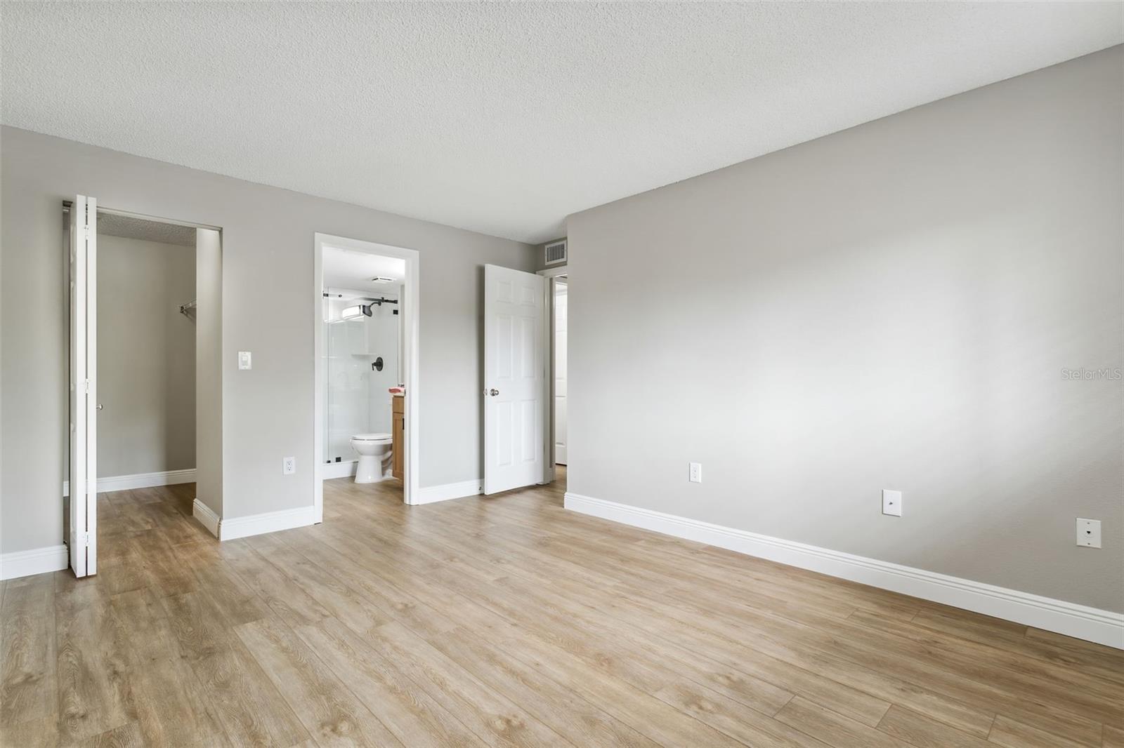 A view of the Primary bedroom shows how light and airy the room is.  The walk in closet is large and the en suite bathroom is a spa like surprise!