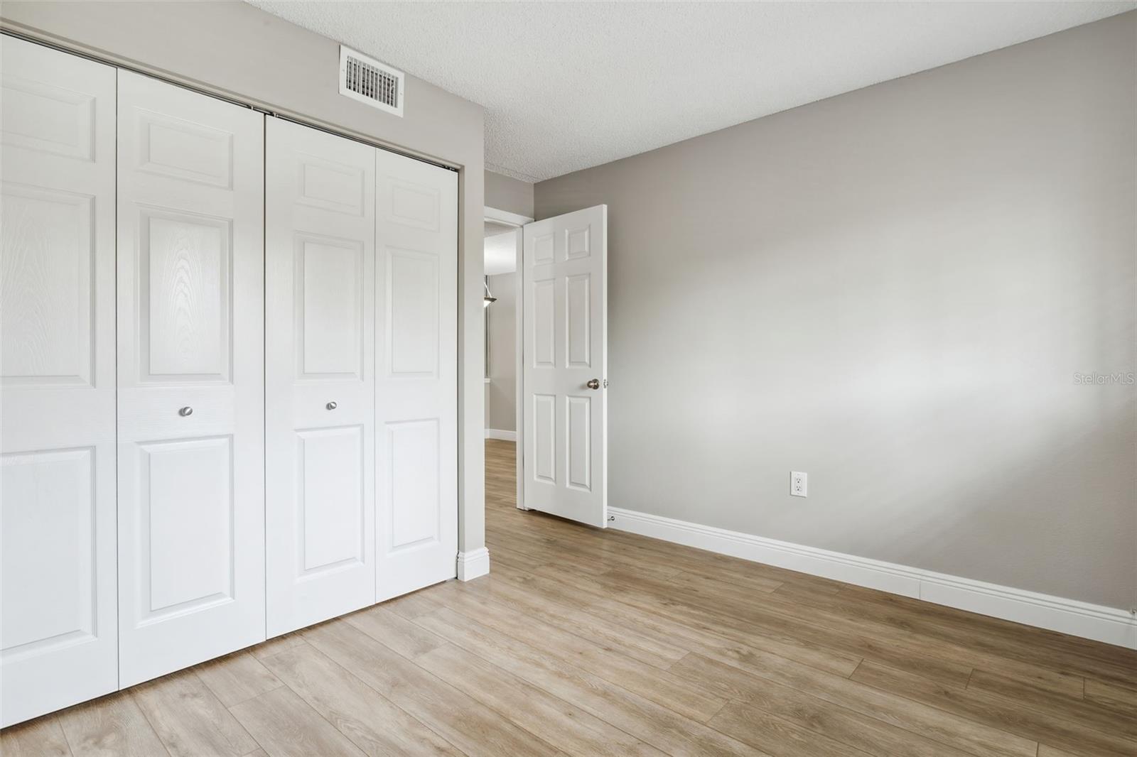 View of the double door closet and door to hallway. Very comfortable, completely painted, and new floor.