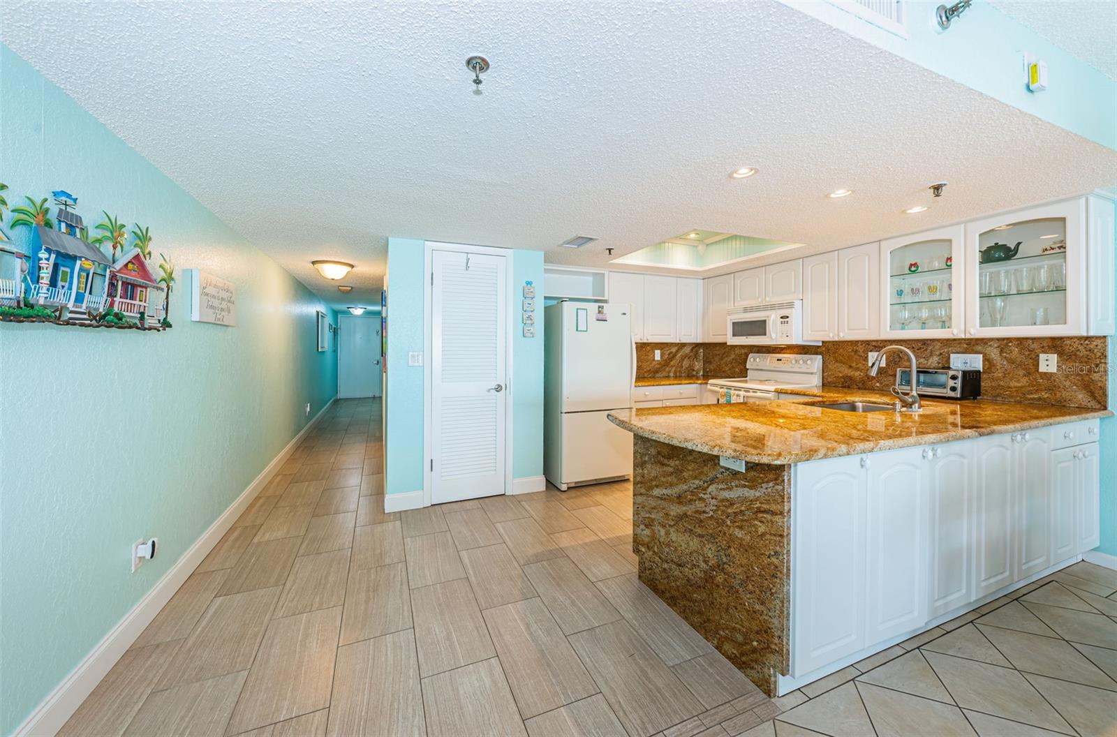 ... SPACIOUS ONE BEDROOM - LOOKING TOWARDS HALLWAY TO BATHROOM AND BEDROOM SUITE. NOTE: LOUVER DOOR TO LEFT OF REFRIGERATOR IS MECHANICAL ROOM. A/C LOCATED HERE.