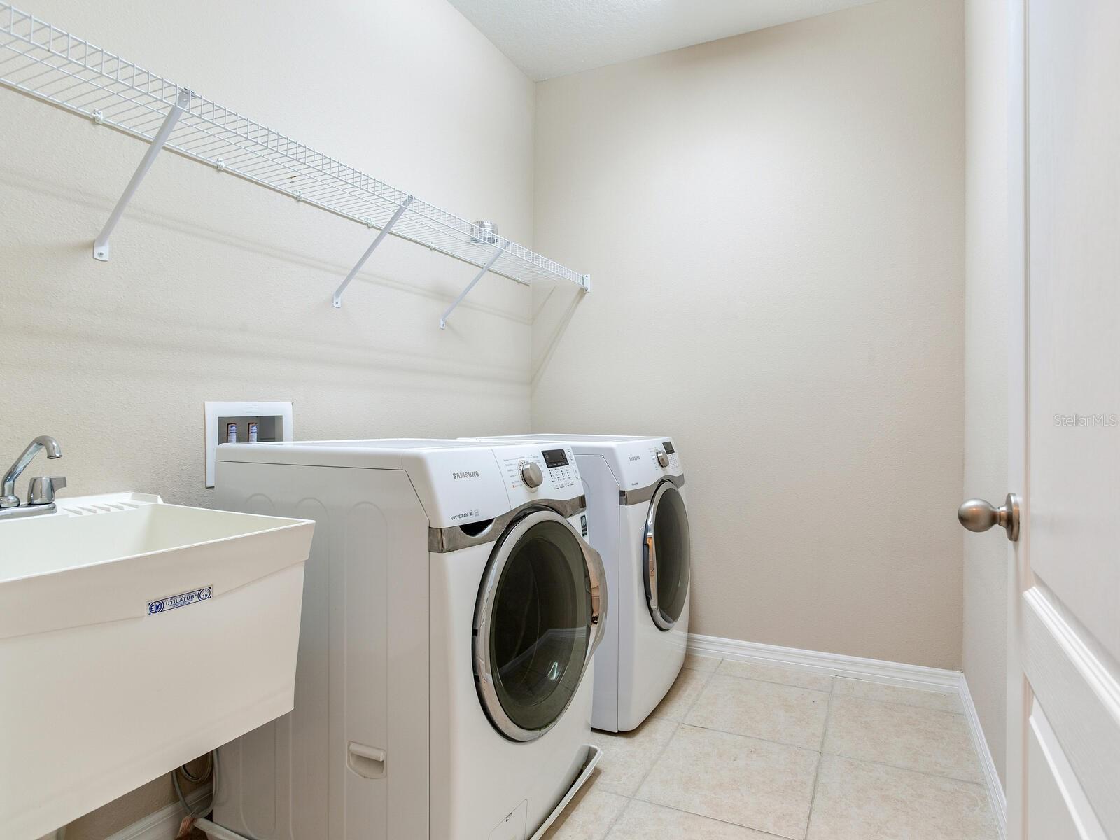 Frontload Full size washer and dryer upstair laudryroom with a sink