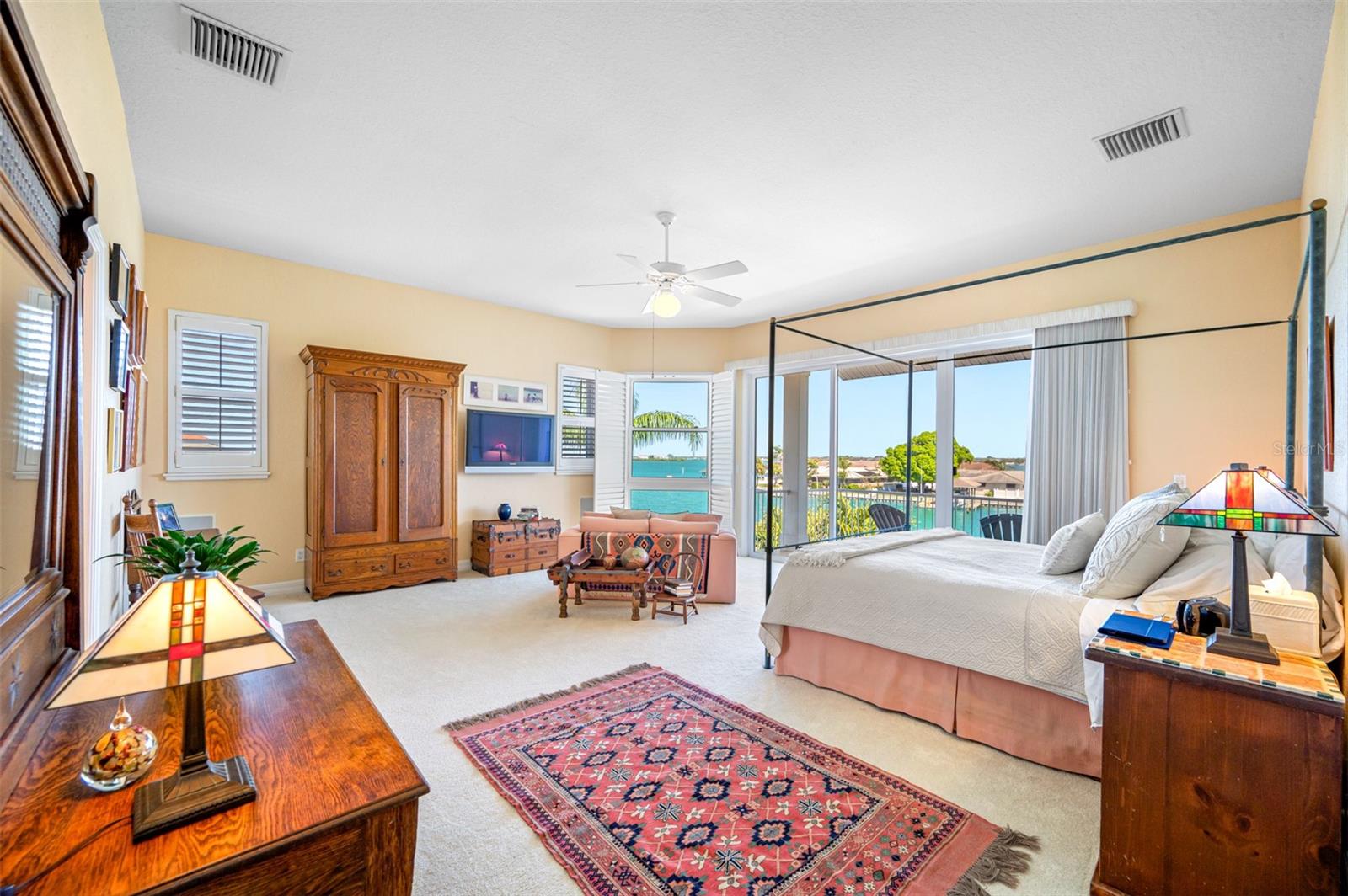 Primary bedroom suite with sitting area, magnificent views, and access to the balcony overlooking Clearwater Harbor