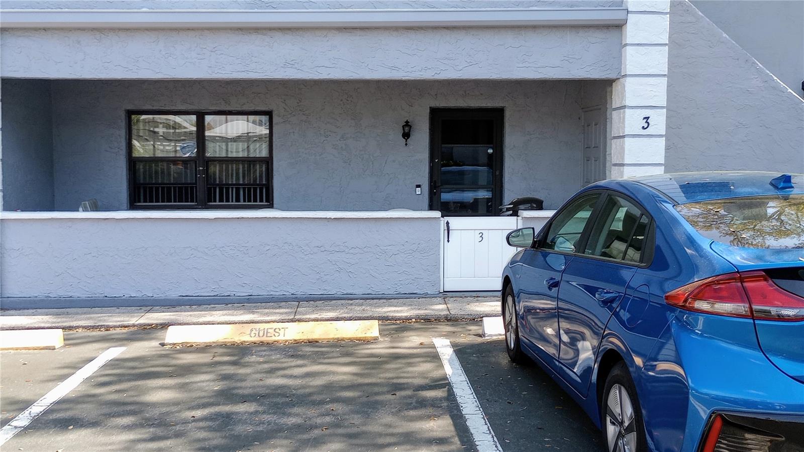 front of home with parking space- blue car