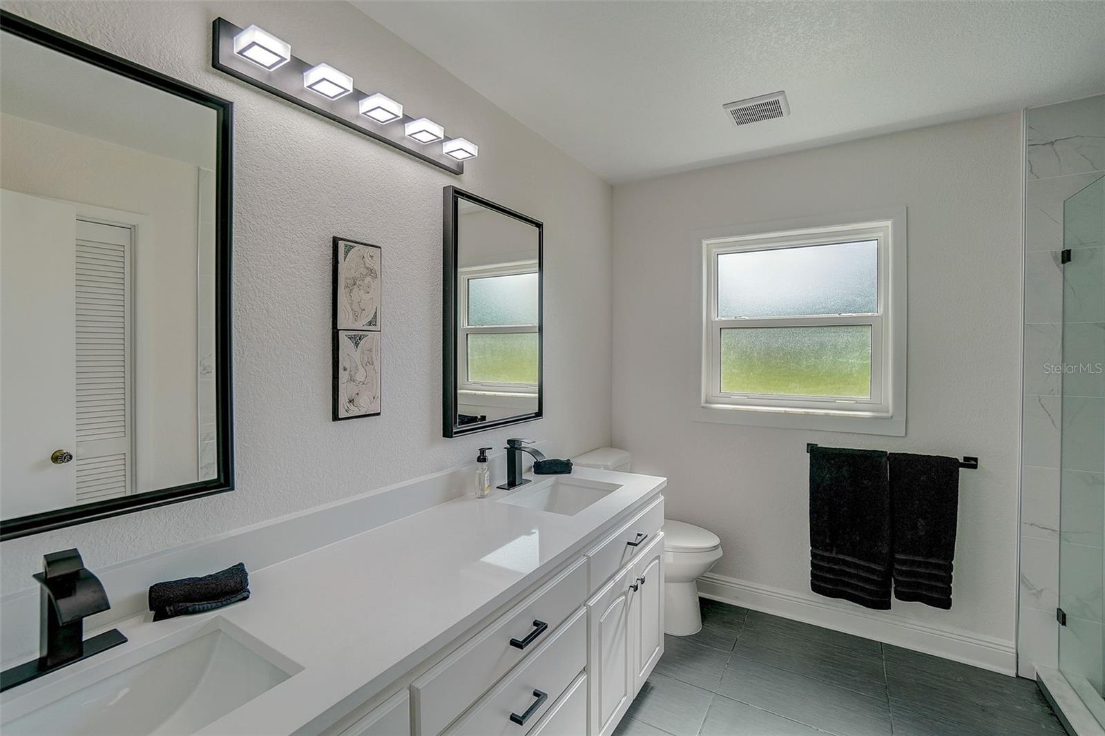 COMPLETELY REMODELED BATHROOM WITH DUAL SINKS AND MODERN SHOWER