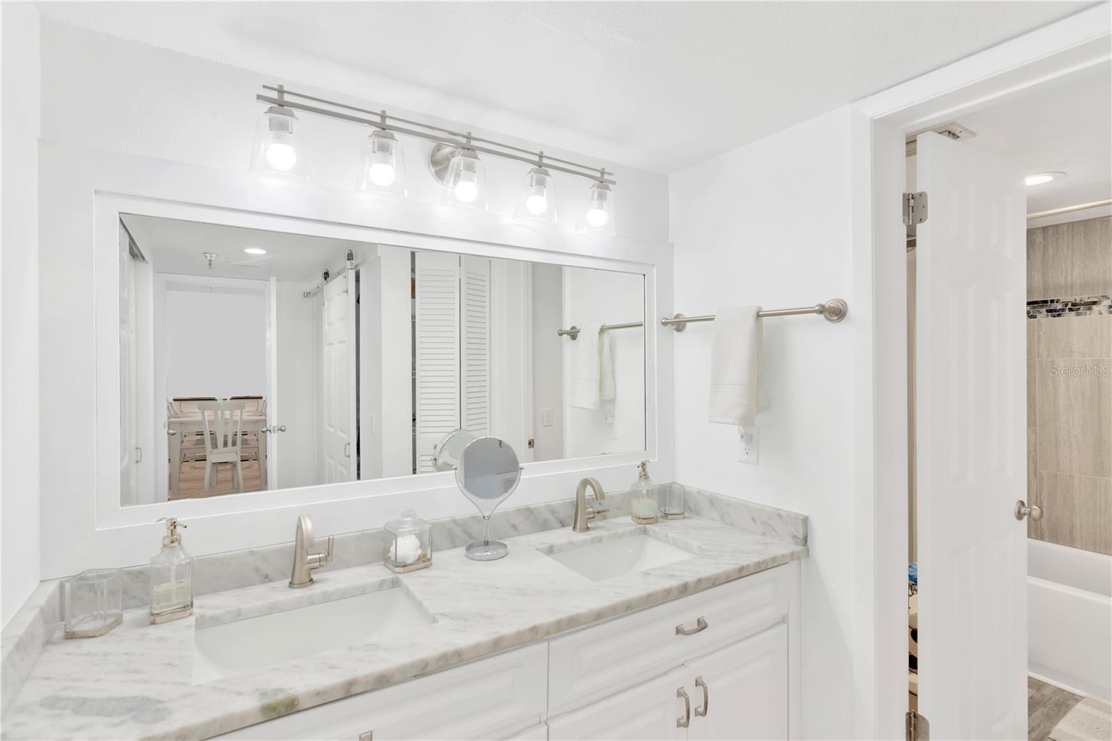 Dual sink vanity, custom lighting and lower cabinet space for storage.