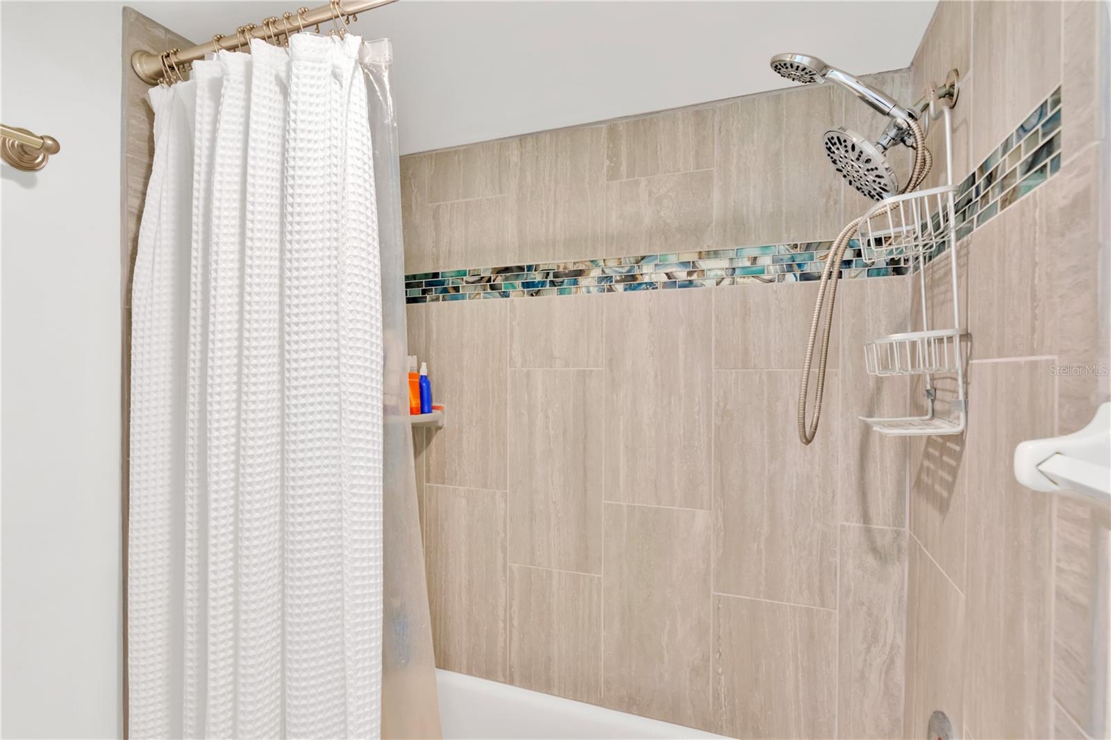Tub/shower combination with listello accent for added artistic interest.