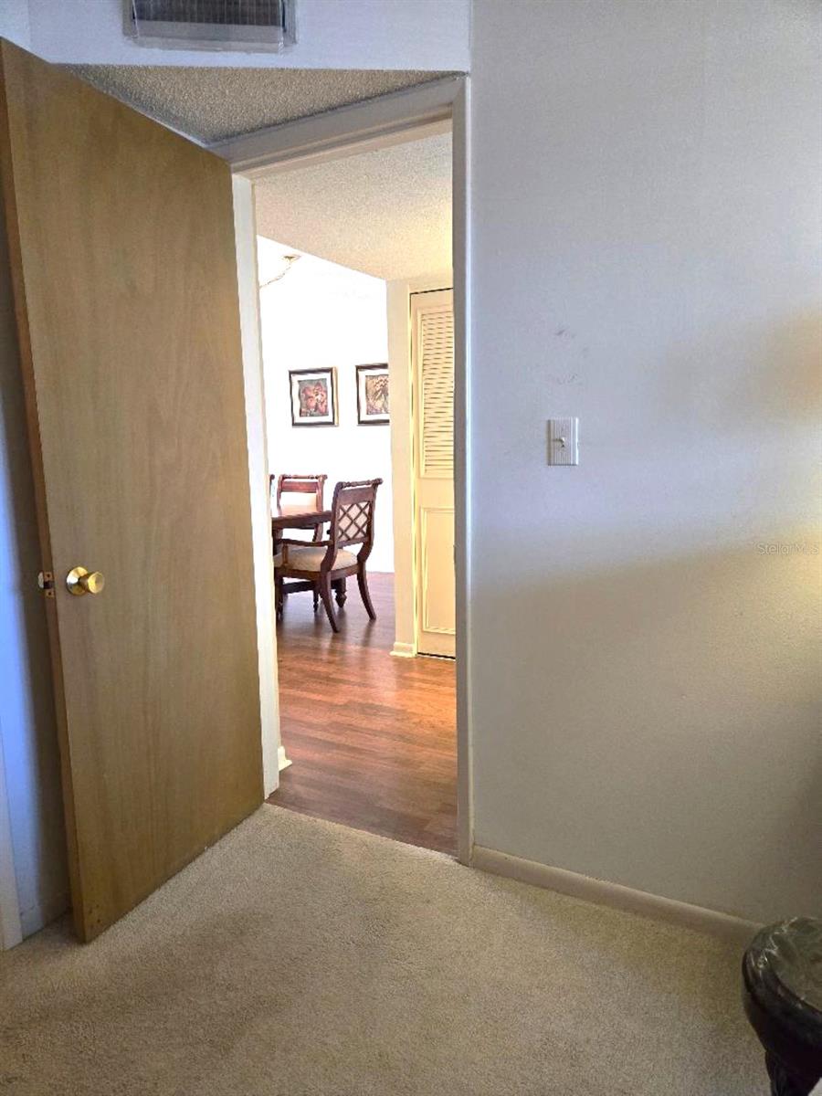 Exiting Primary Bedroom into Hall way between Kitchen and Dining Room