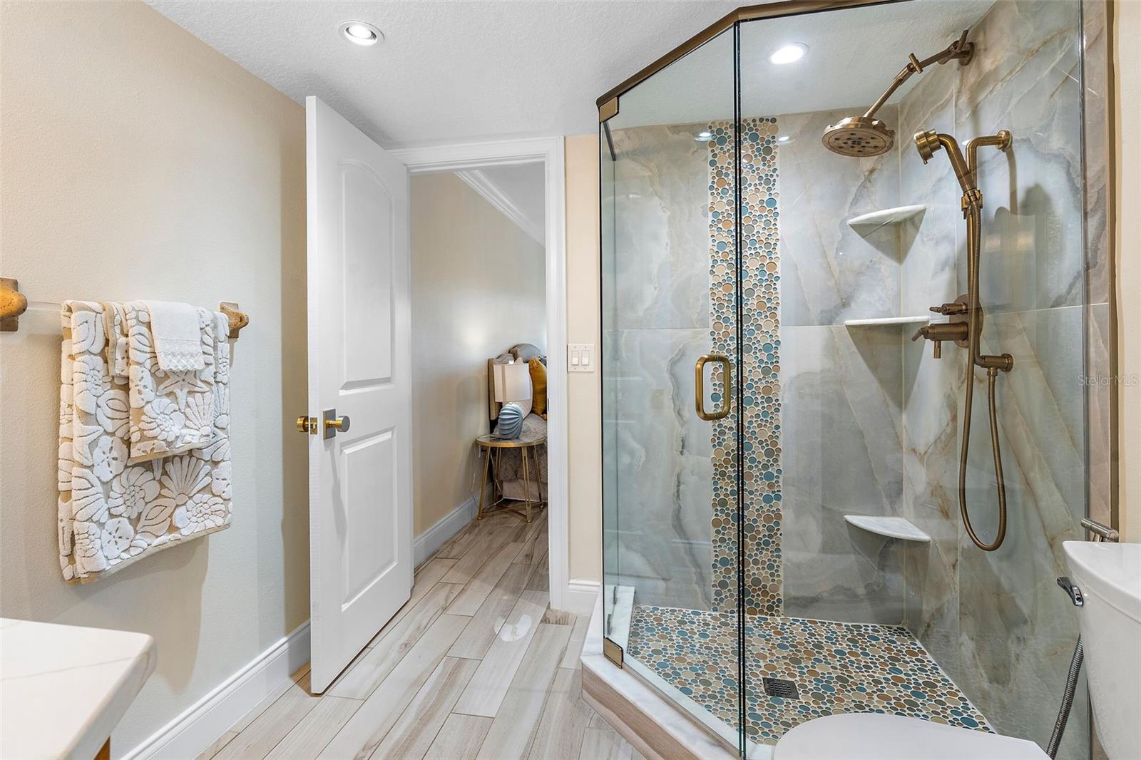 The stylish shower has just been remodeled in an elegant, yet beachy style.