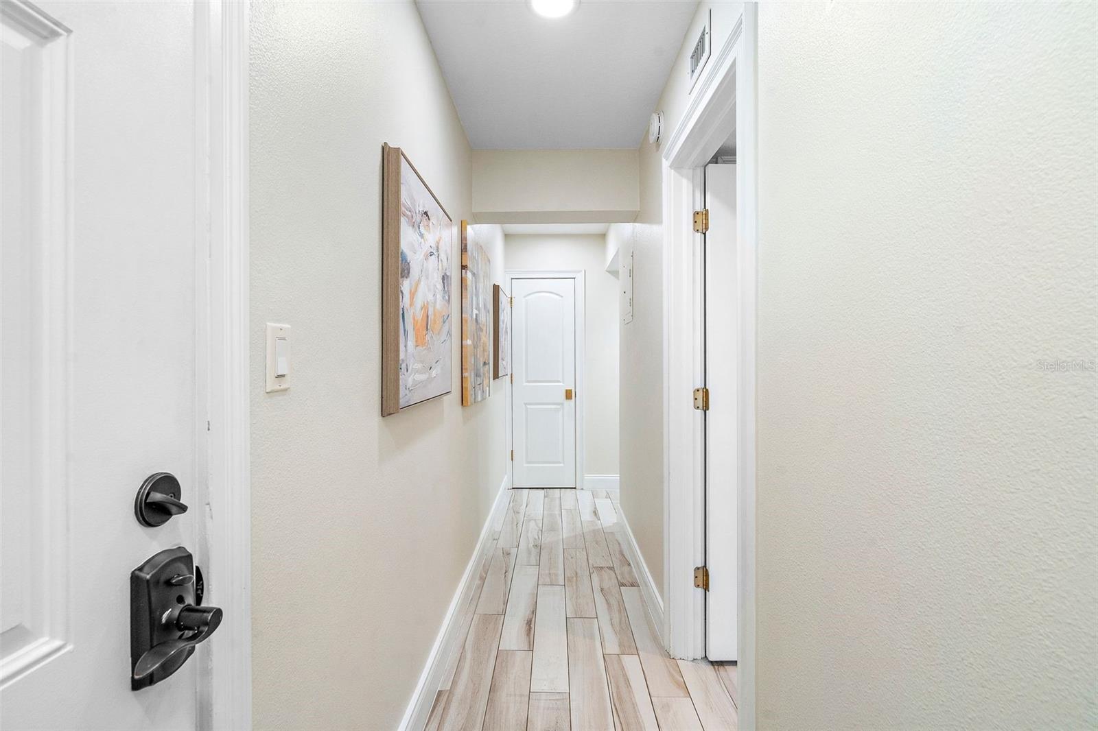 At the end of this hallway, there are three doors: The one you see is where the full-size stackable washer & dryer are. To the left is the Guest bedroom, well away from the primary bedroom. To the right is the front door.