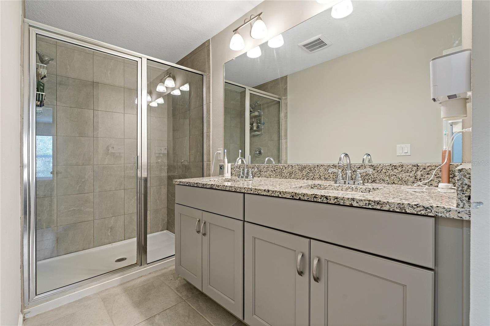 Dual Sinks With Granite Countertops & Glass Enclosed Shower
