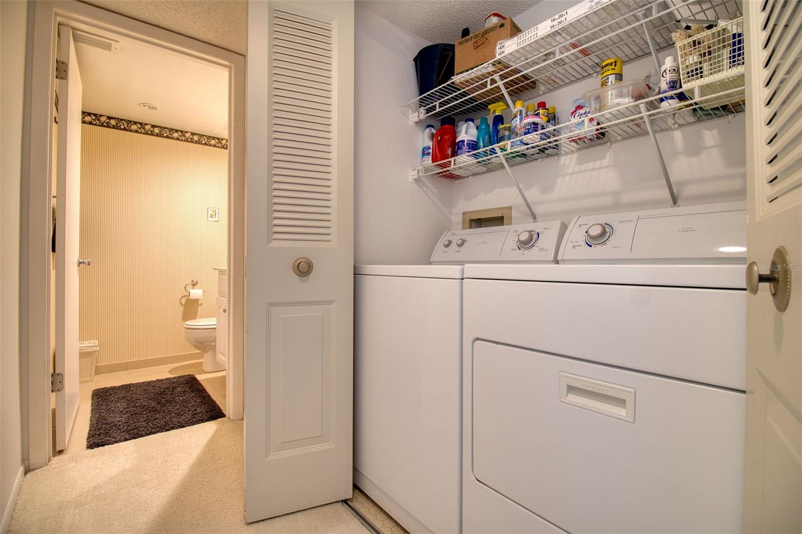 Washer & dryer in hall closet leading to half bath.