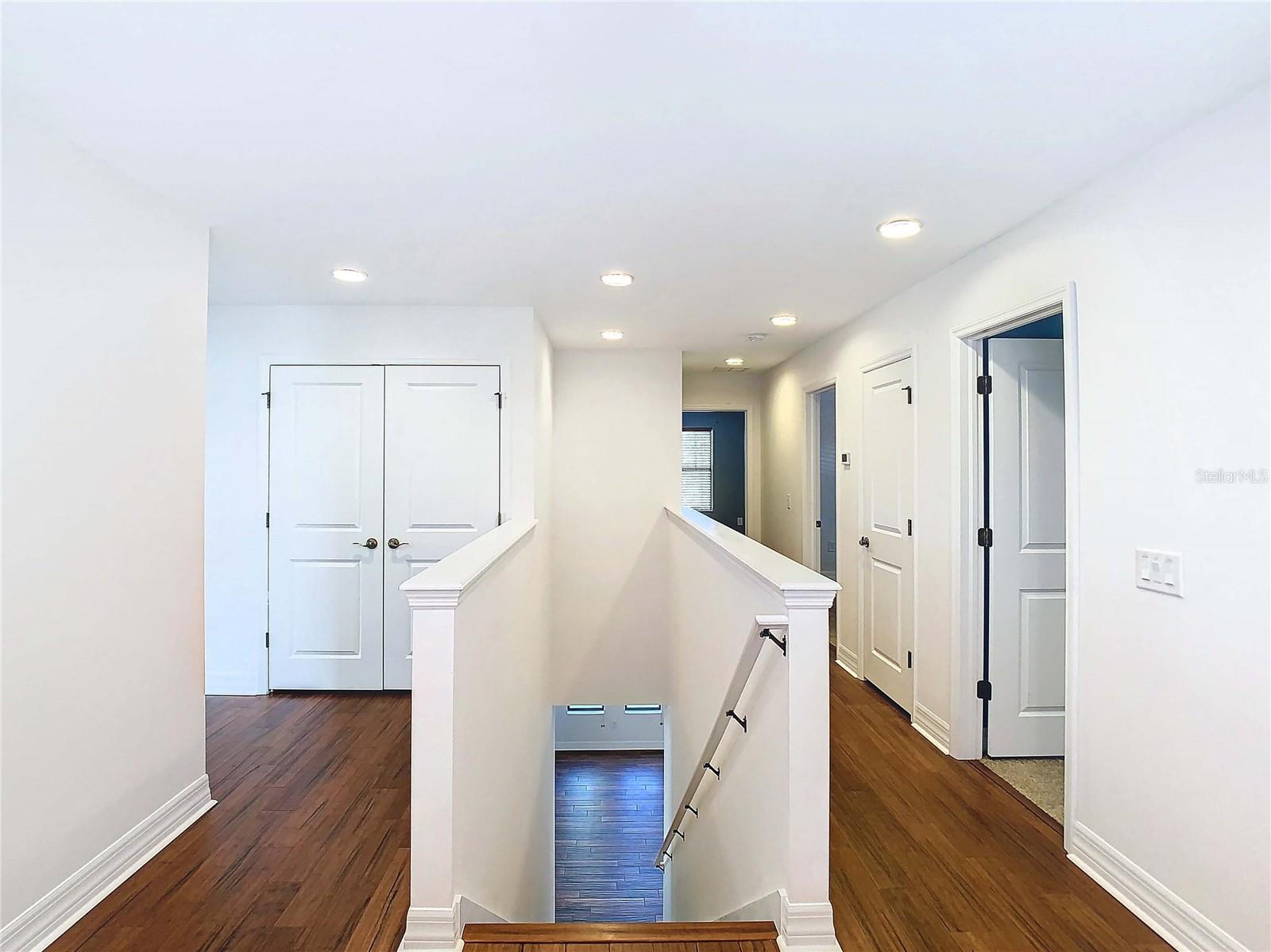 Upstairs hallways featuring wood-like vinyl flooring