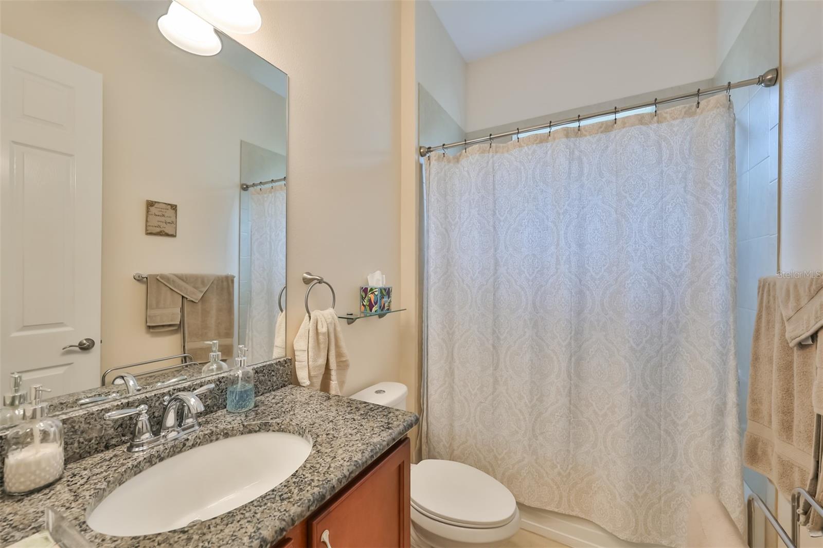 Guest Bathroom has granite countertops and matching cabinetry, porcelain tile flooring with a tub/shower combo.  Located right next to Bedroom #2, for ultimate privacy.