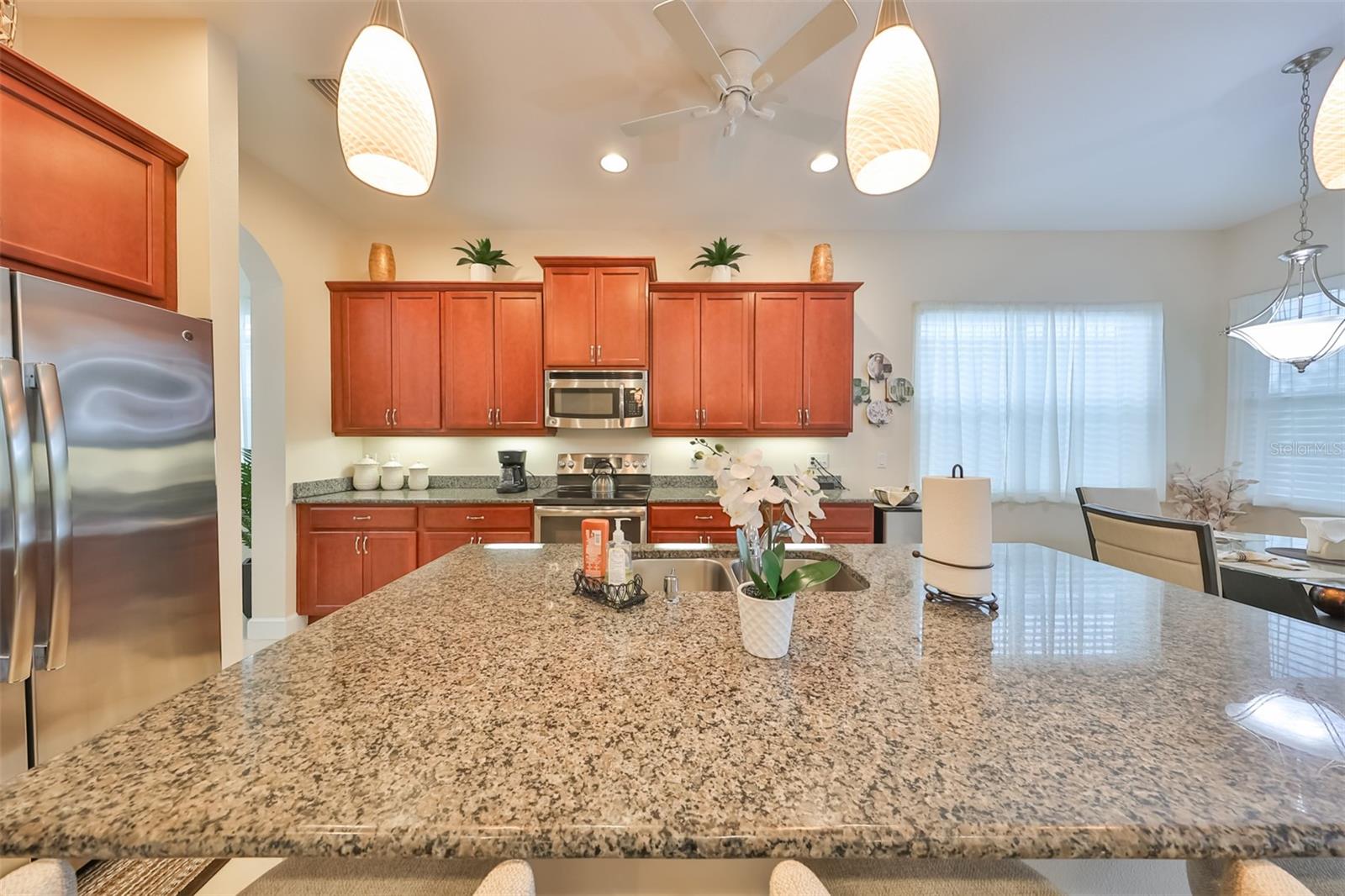 A beautiful and functional breakfast bar with lots of granite countertops for any task, custom pendant lighting and newer stainless-steel appliances.