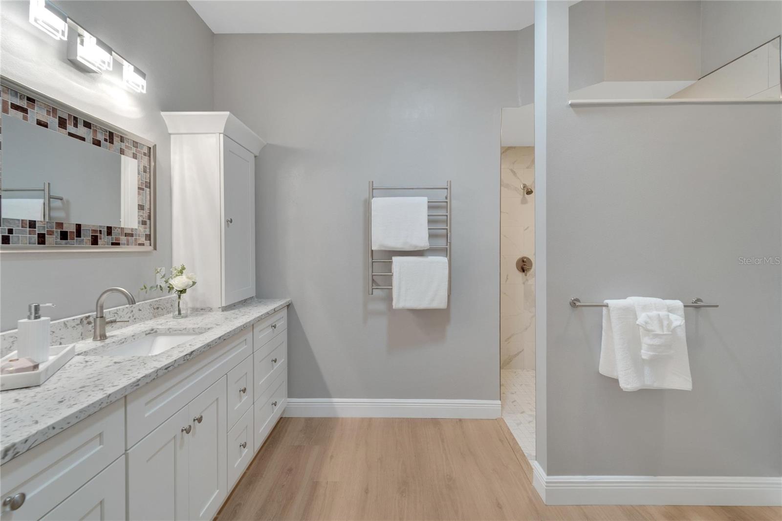 Primary Bathroom with Shaker style cabinetry with soft close doors and drawers, quartz countertops, built in electric for your hair dryer, toothbrush, shaver.