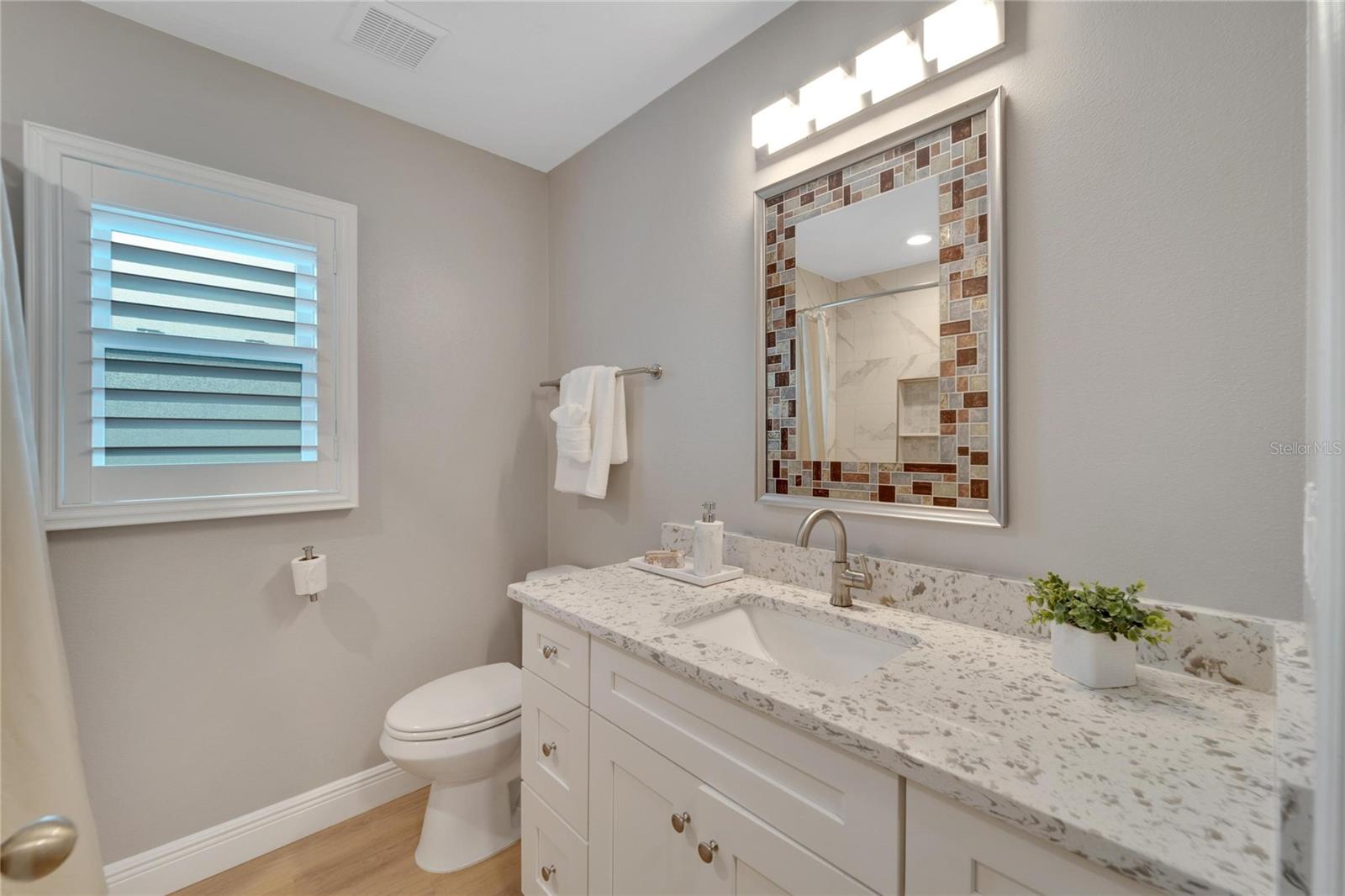 Bathroom #2, Shaker style cabinetry with soft close drawers and doors, updated lighting, stylish mirror, LVP flooring, Plantation Shutters