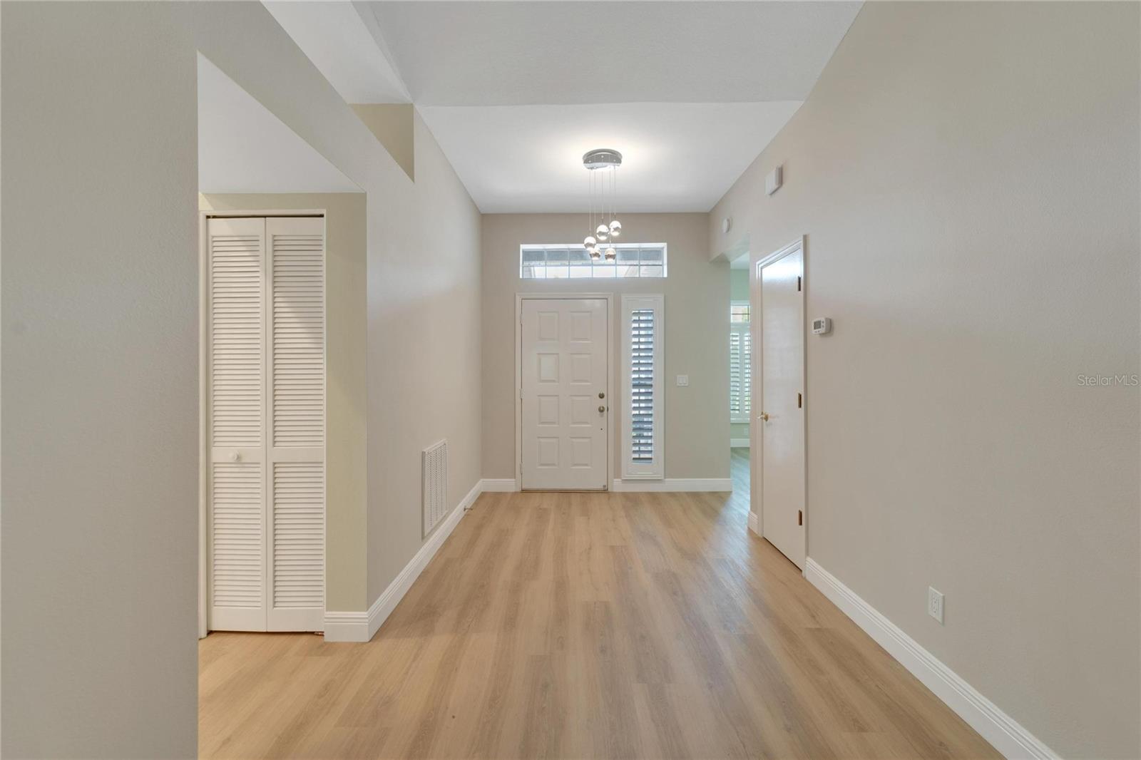 Foyer with LVP Flooring and spacious coat closet at entry