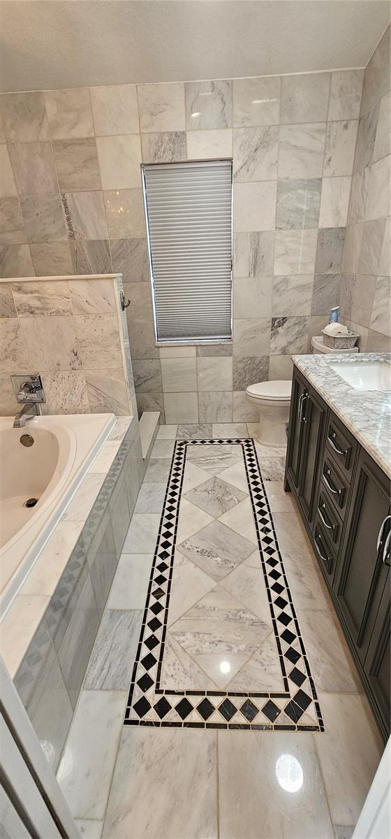 Marble flooring, tile and bright lighting in master bathroom