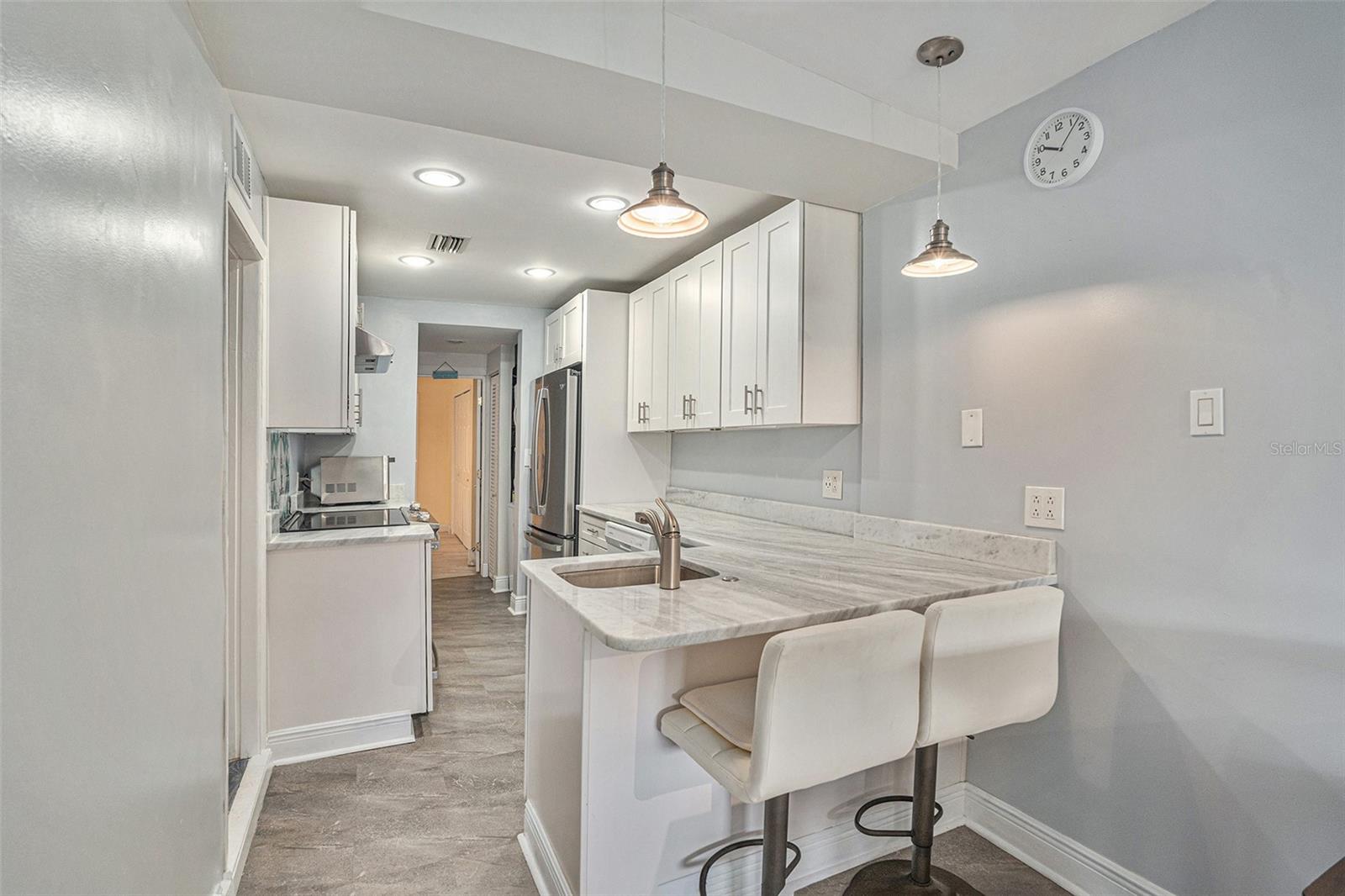Lovely breakfast bar is chic and tastefully done with granite, stainless and beautiful cabinets with soft close features. Calm coastal themed color scheme ..do you hear the ocean calling?