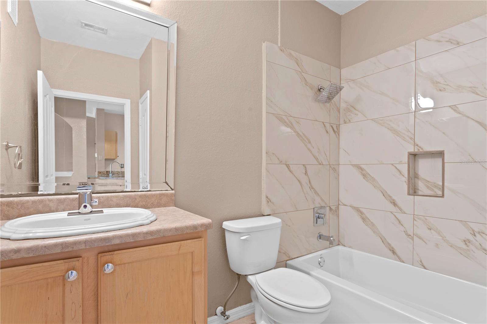 This spacious bathroom is complete with a newly tiled tub/shower and a coveted linen closet.