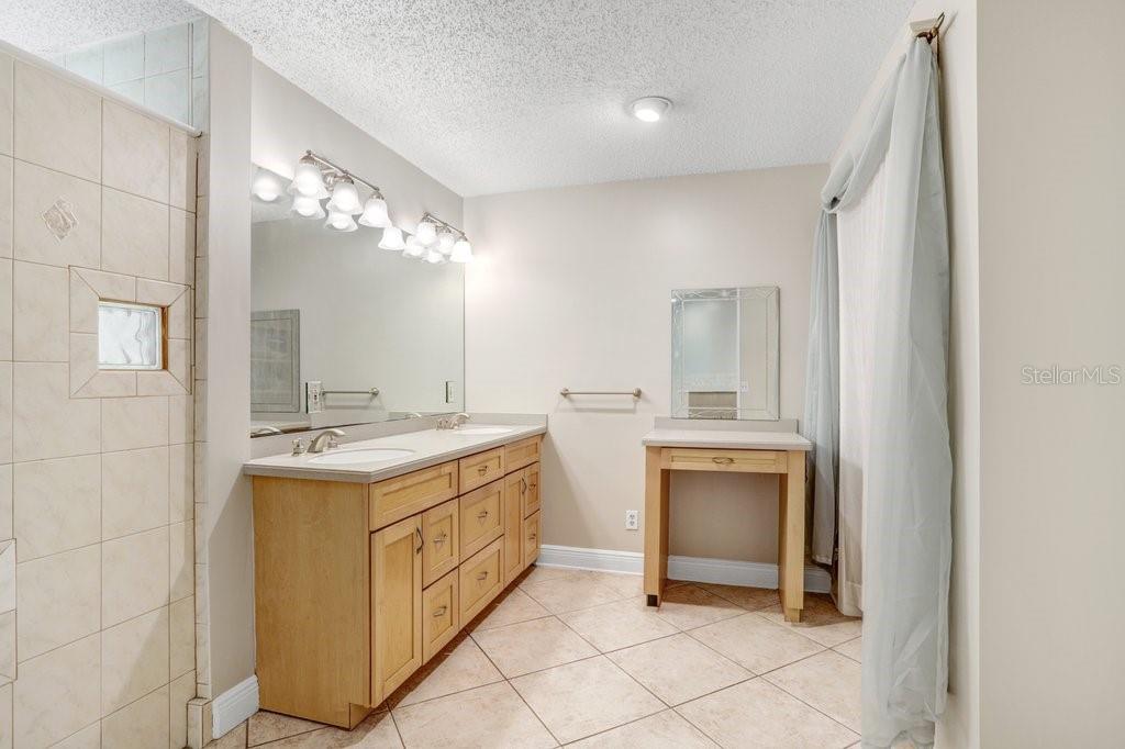 Ensuite bathroom with dual sinks, vanity, and closet