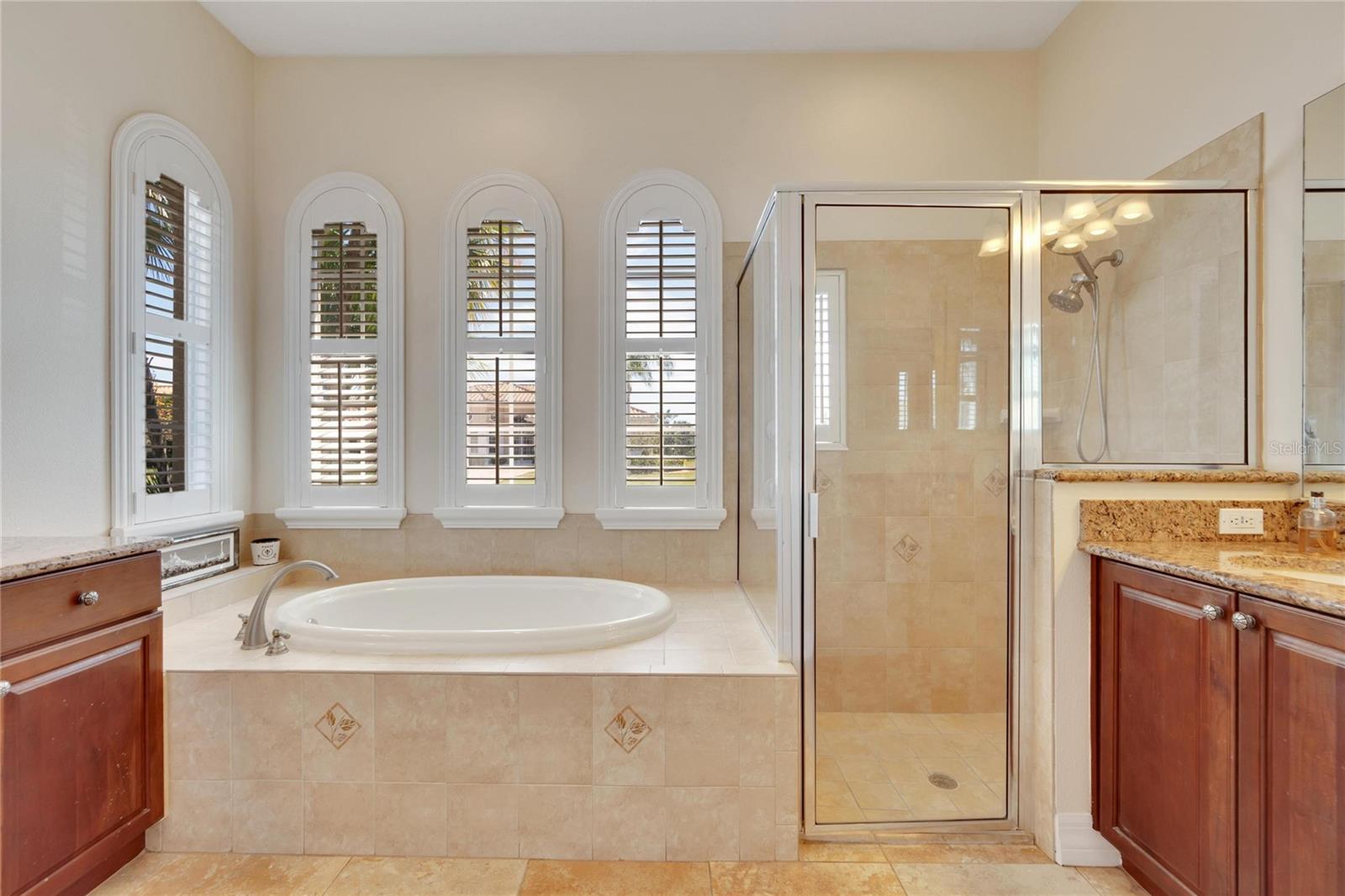 Owner's ensuite is visually stunning with the quad set of arched windows with plantation shutters.