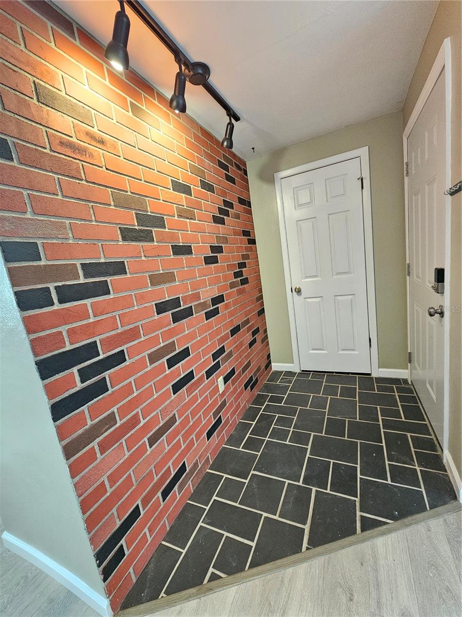 Brick accented Foyer with Coat Closet