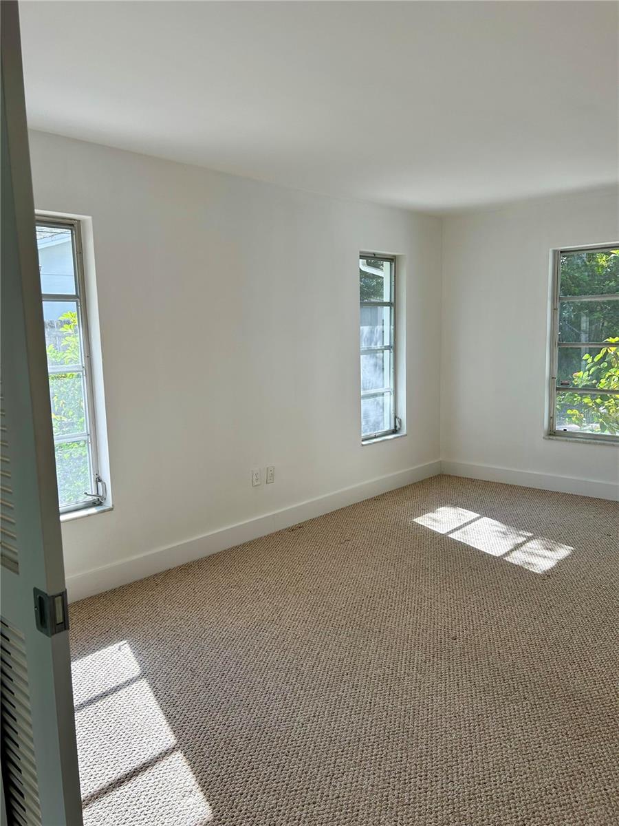 Primary  Bedroom with lots of natural light, features a walk in closet, en-suite bathroom, and large vanity area.