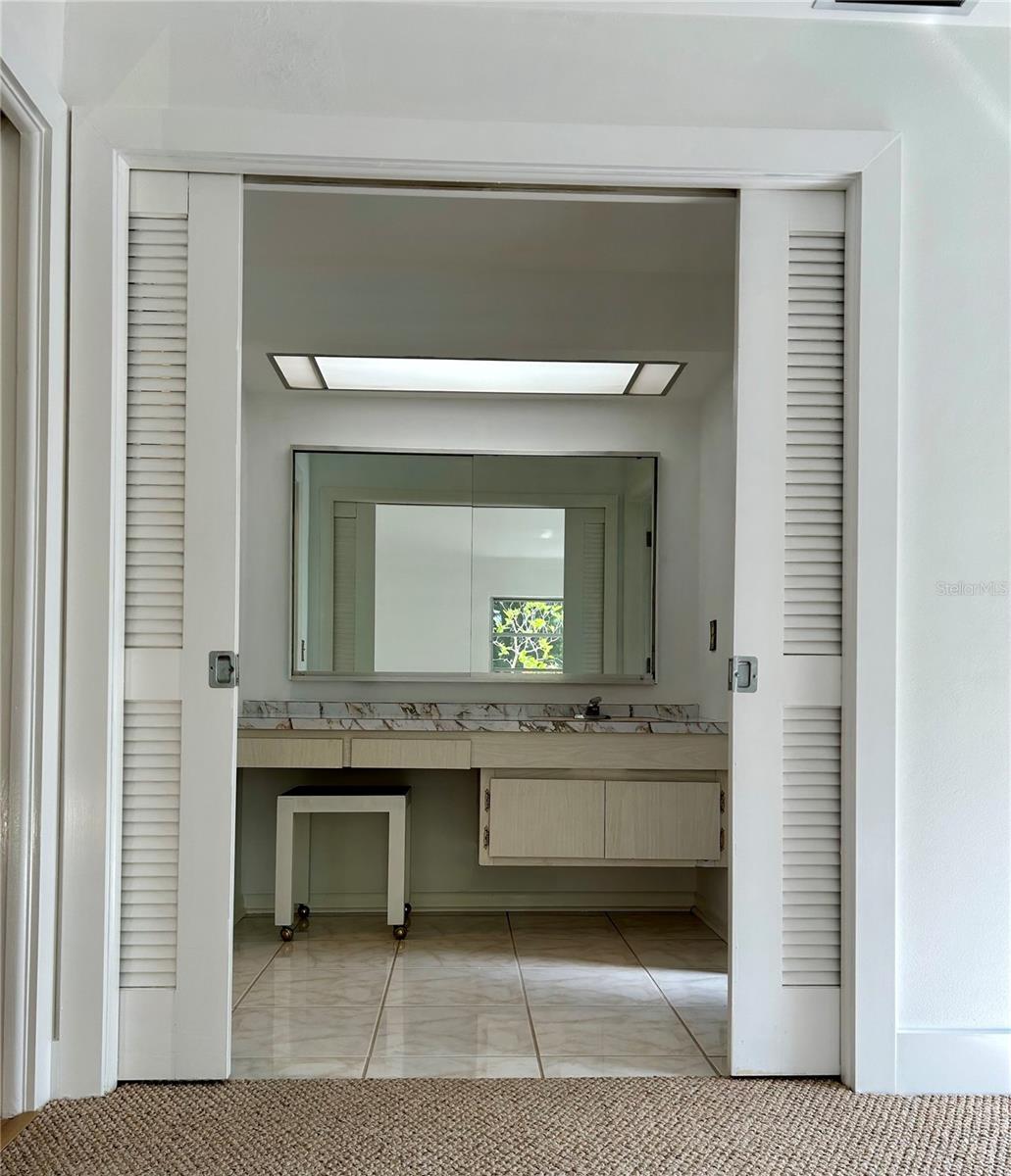 Blast from the past, this vanity area offers plenty of space, light, and large mirror for "getting ready"
