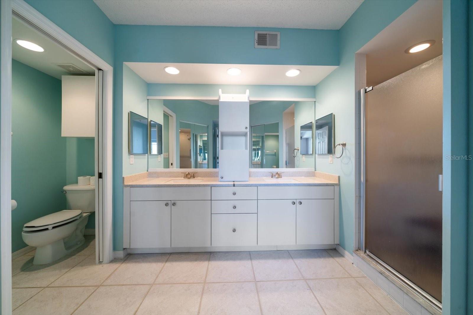 SPACIOUS PRIMARY BATHROOM WITH DUAL SINKS, WATER CLOSET, TWO WALK-IN CLOSETS AND ROOMY SHOWER.