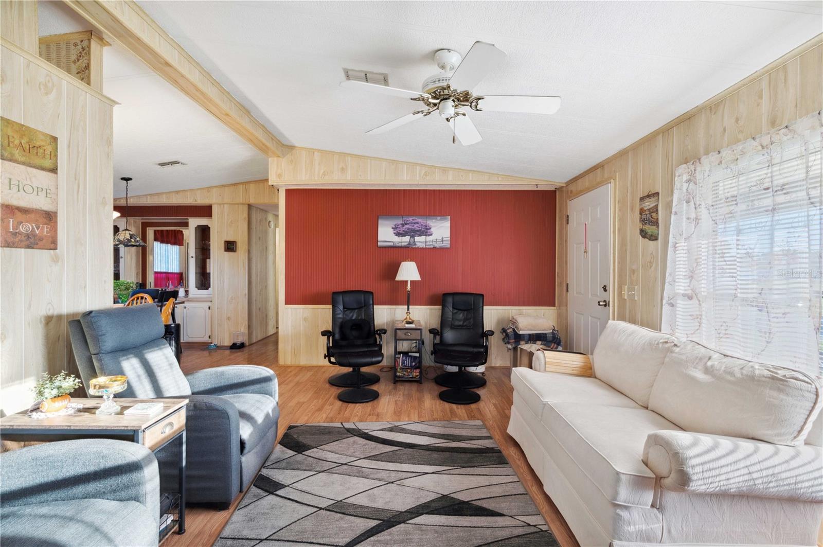 Living room has laminate floor, ceiling fan, and much more.