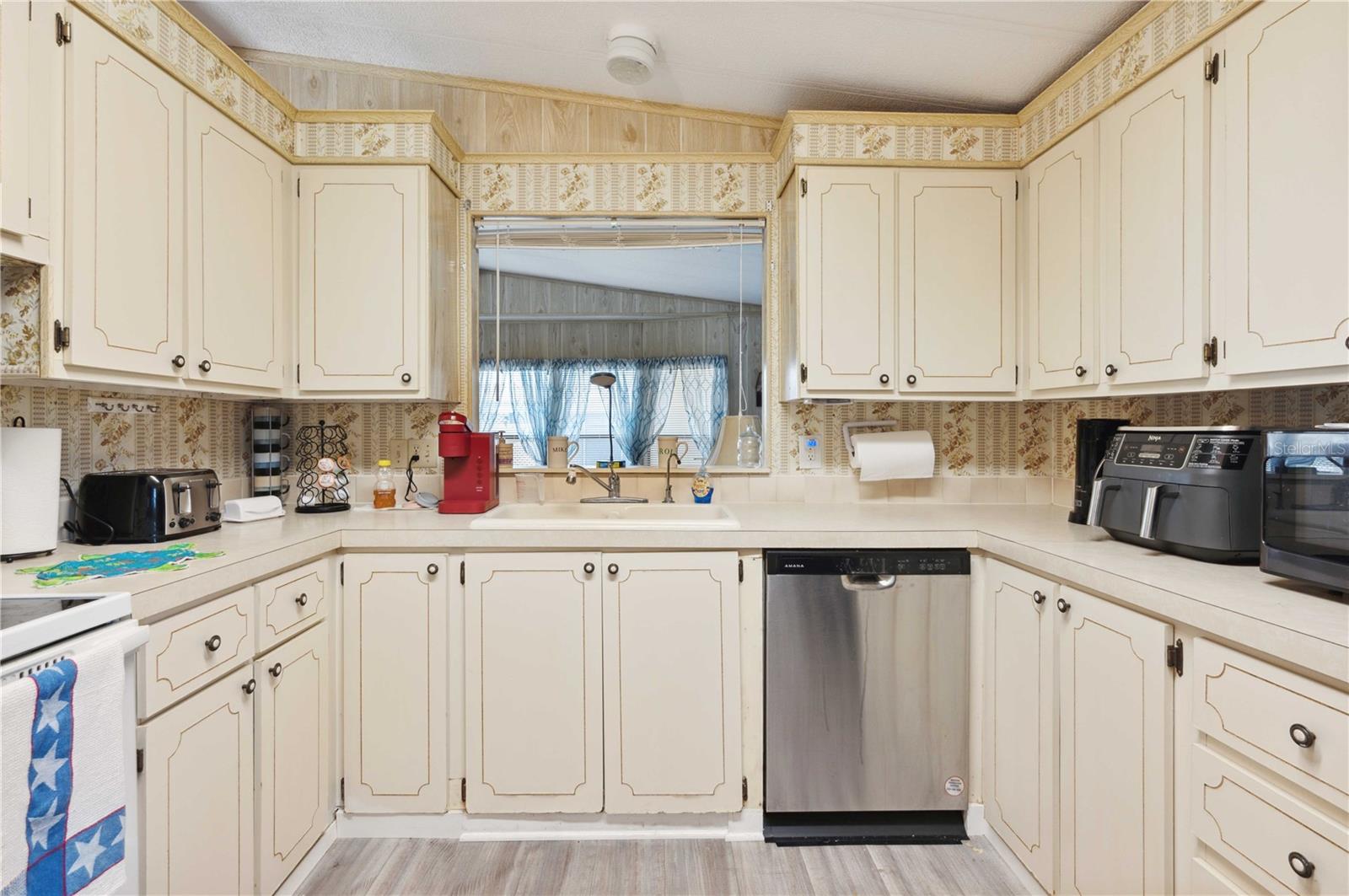 This kitchen offers dishwasher, range, newer refrigerator, and ample storage.