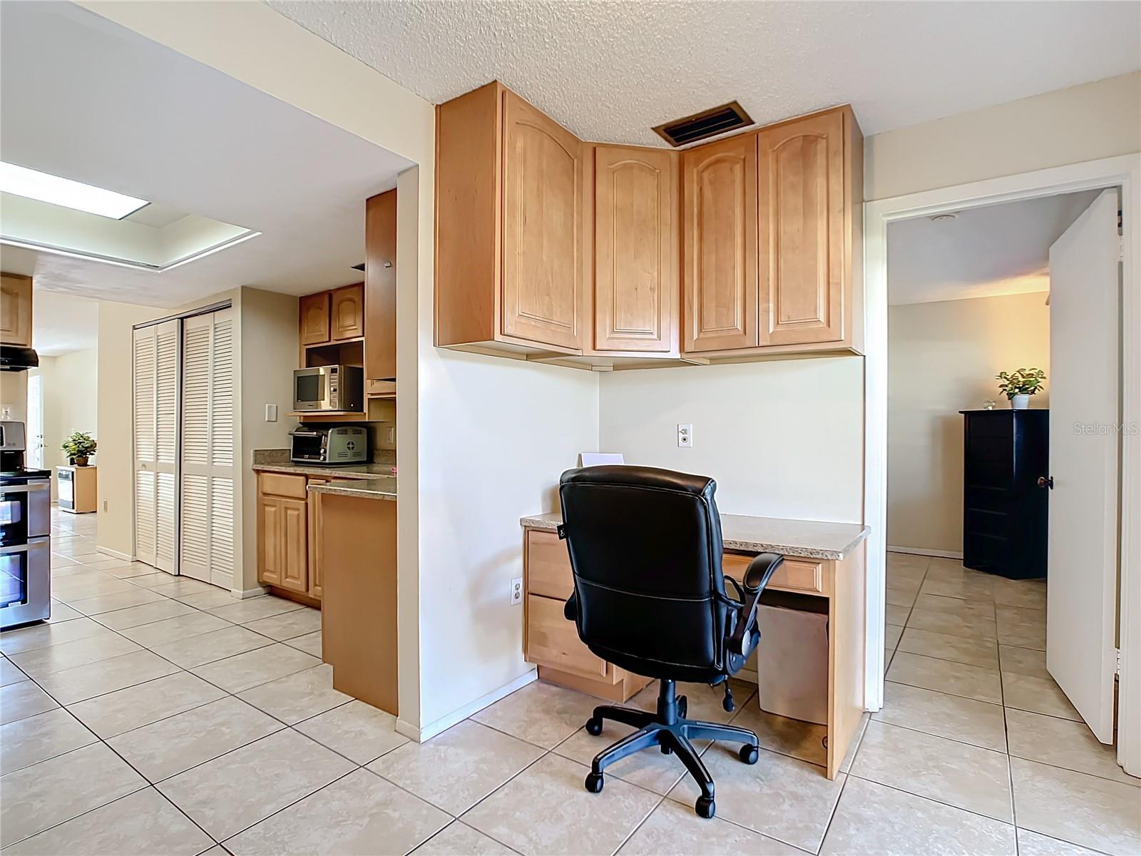 Office with wood cabinets and granite desk top - matches kitchen