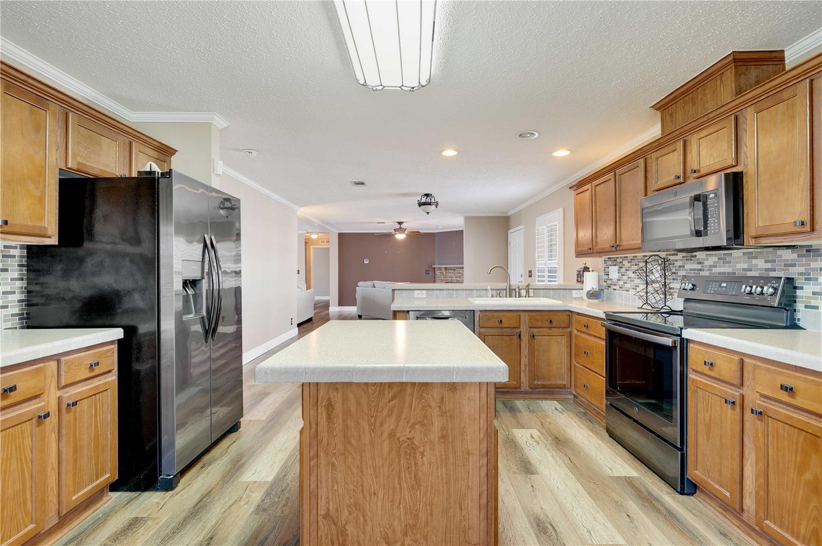 The kitchen has many upgrades including real wood cabinets, center island, tile back splash, closet pantry, and ample storage/space for any chef.