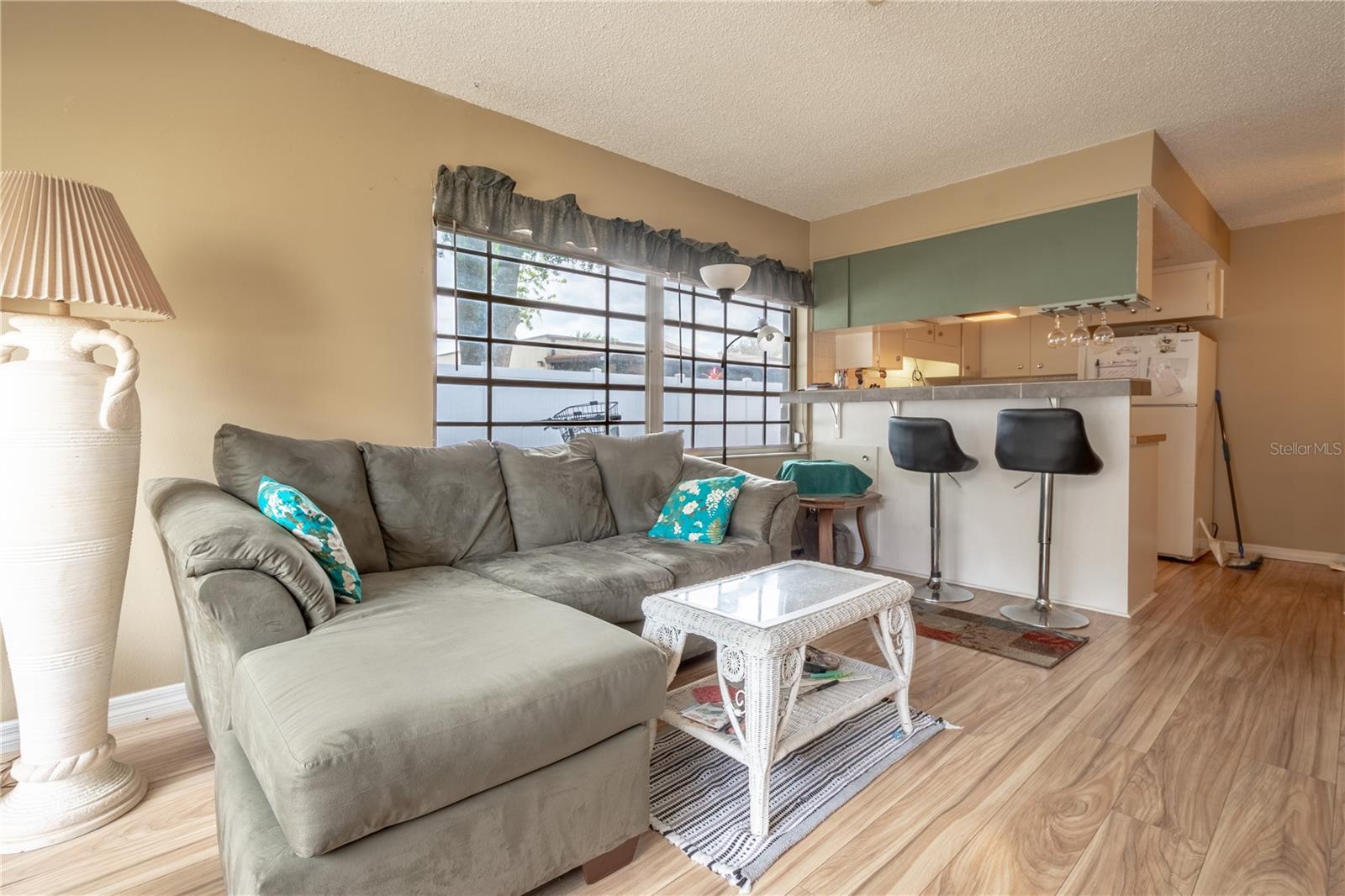 The living room is open to the kitchen and breakfast bar and features wood laminate flooring.