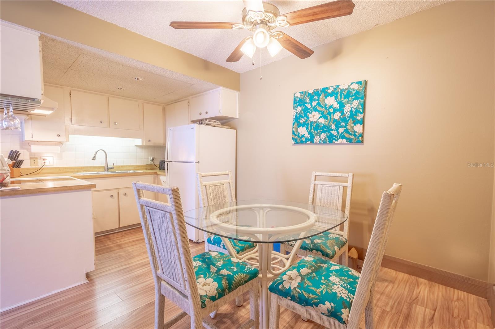 The kitchen has room for your dining table, illuminated by a ceiling fan with a light kit.