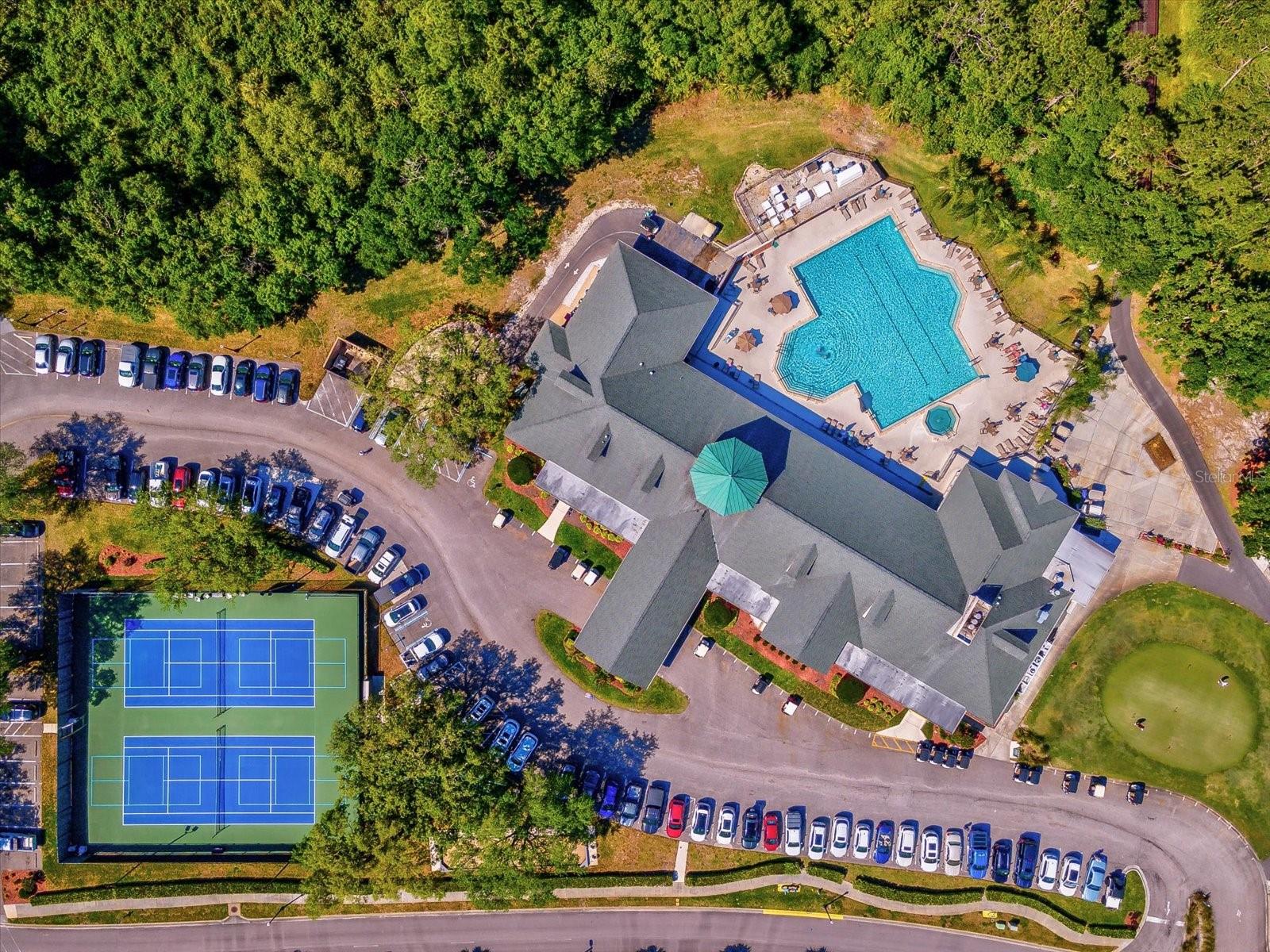 Drone views of clubhouse, heated pool, spa, tennis/pickle ball courts